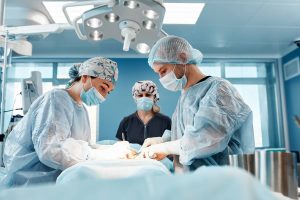 urgeons performing abdominal adhesiolysis procedure