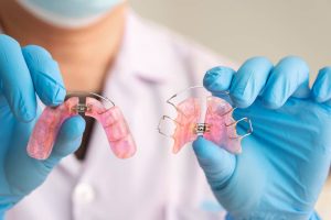 orthodontist holding removable appliances designed to straighten teeth